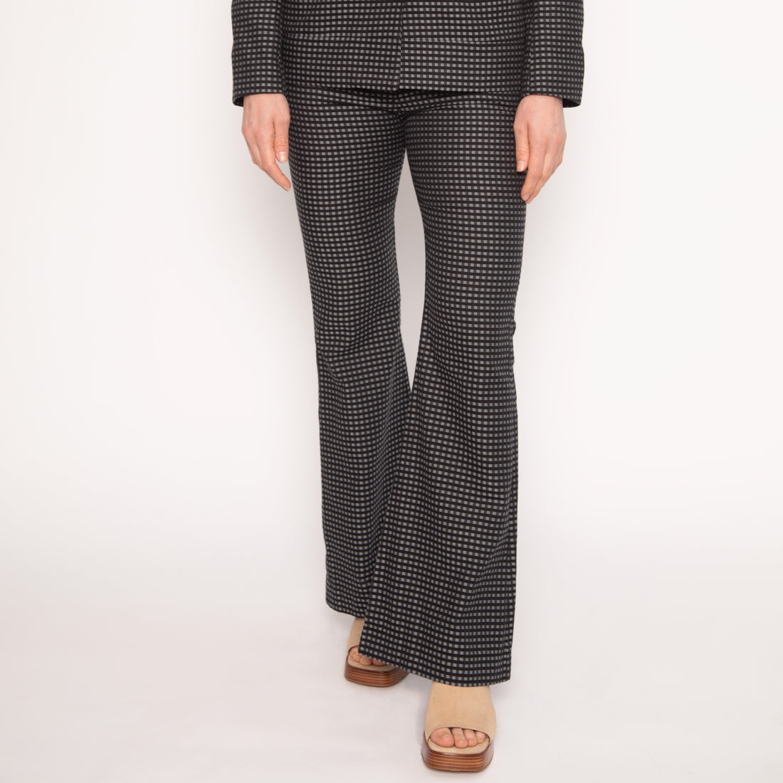 notre pantalon tailleur évasé en coton, orné de petits carreaux gris et noirs, une pièce emblématique de la collection NUYHENN. Ce modèle allie confort et sophistication, parfait pour une silhouette élégante.

Conçu en France, ce pantalon met en avant notre engagement pour une mode responsable, utilisant des matériaux naturels et durables. Son motif classique et chic s'adapte à toutes les occasions, qu'il s'agisse d'une journée au travail ou d'une sortie en soirée.