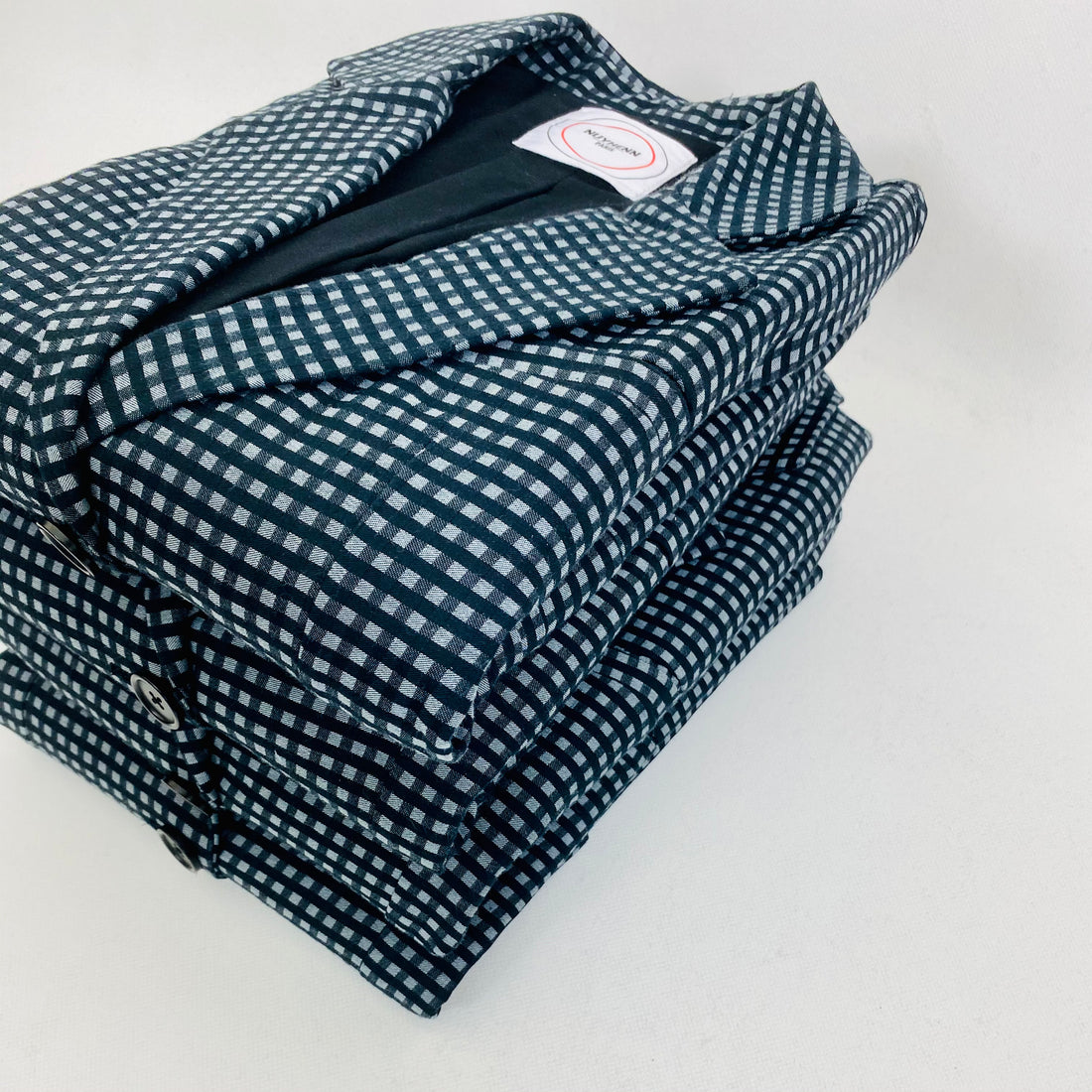 notre tailleur à petits carreaux Vichy bleu et noir, composé d'une veste et d'un pantalon, fabriqué en France à partir de coton biologique. Cette pièce illustre un savoir-faire artisanal de haute qualité et reflète un engagement profond envers l’écologie. Notre méthode de production responsable privilégie des matériaux naturels et durables, garantissant ainsi une qualité exceptionnelle.